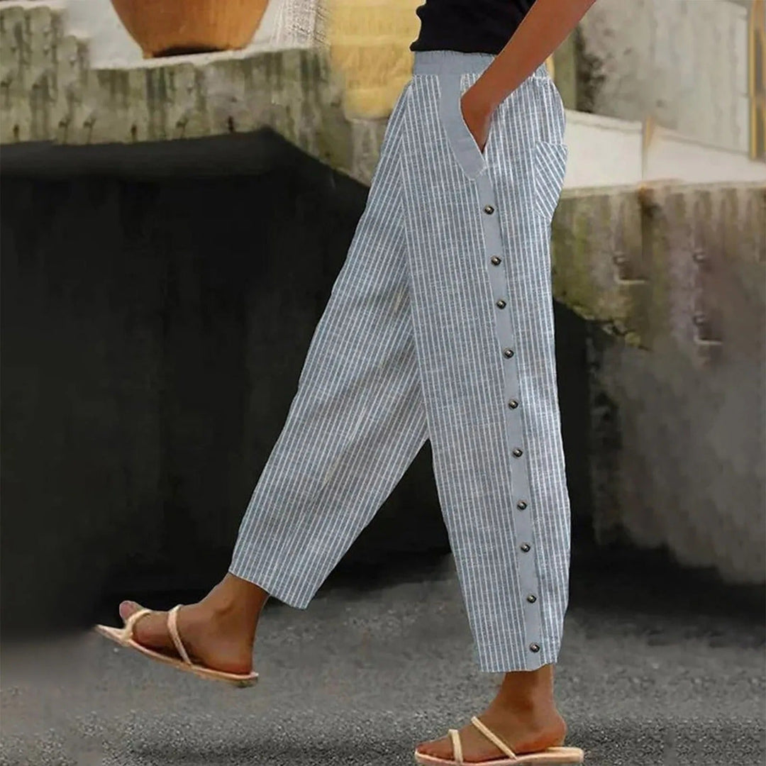 Fashionable women's high-waist striped trousers showcasing decorative buttons and elegant versatile design.