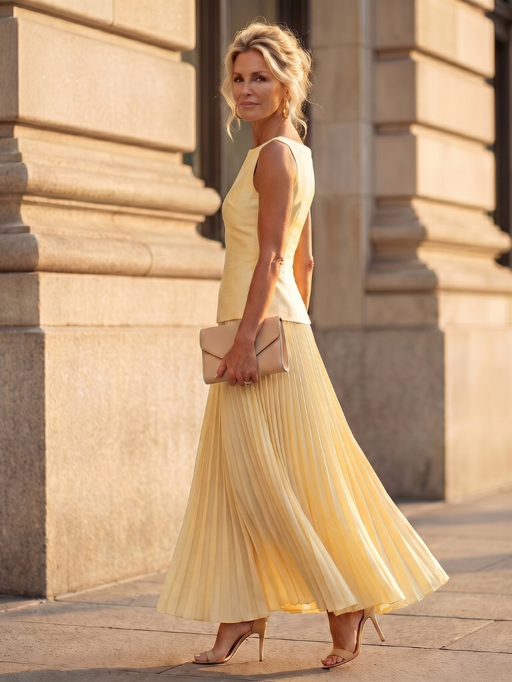 Stylish two-piece women's outfit: structured top & flowing pleated maxi skirt. Ideal for summer events.