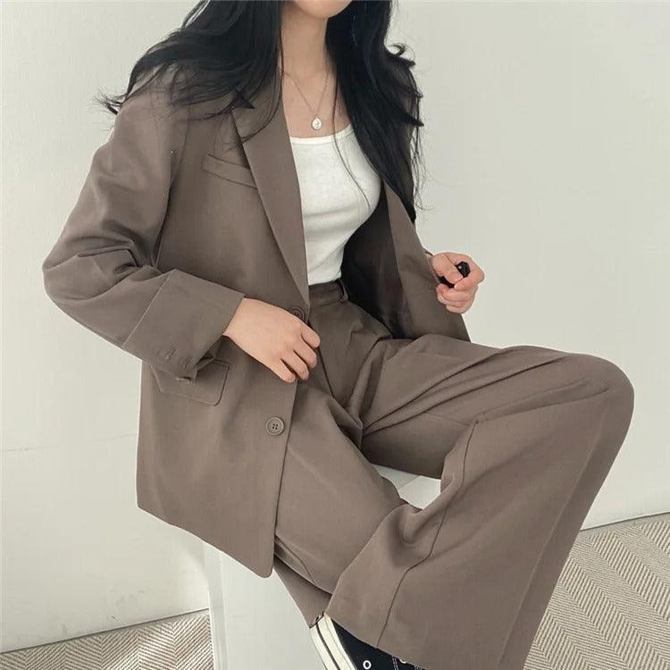 Elegant women's tailored suit set for work, featuring a long blazer and fitted trousers