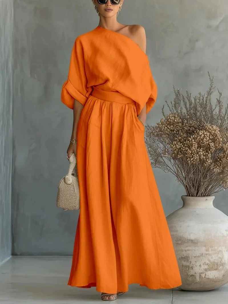 Chic women's fashion two-piece set with a unique asymmetric drape top and relaxed elastic waist wide leg pants.