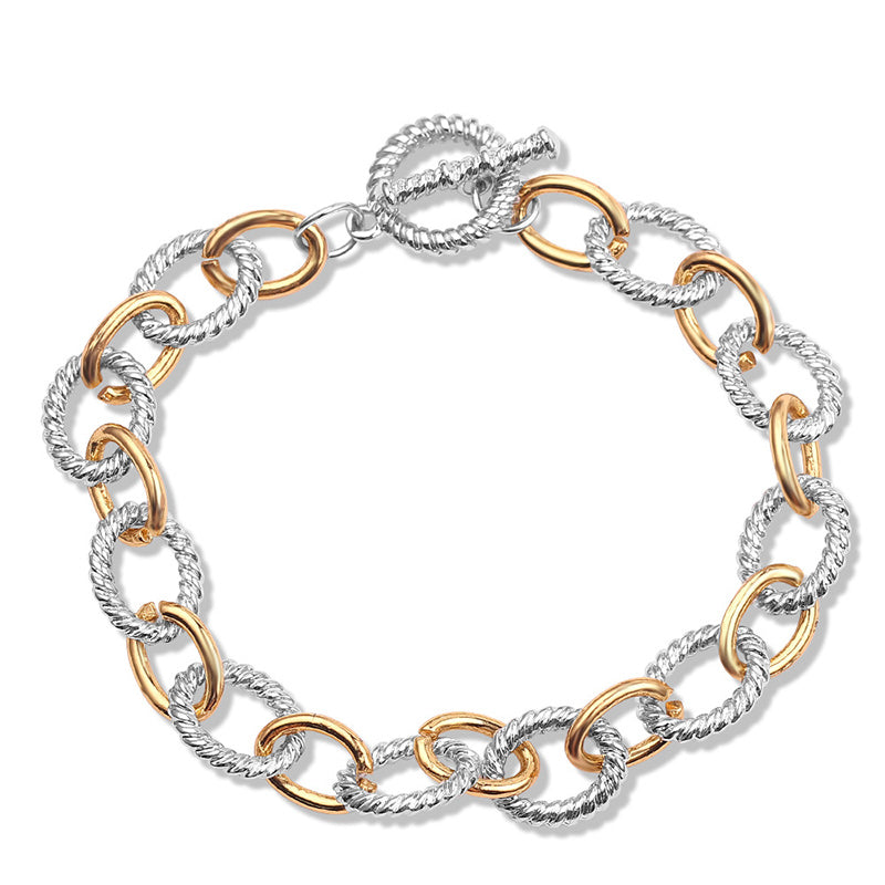 Detailed view of the knot on a women's two-tone twisted bangle bracelet, stainless steel.