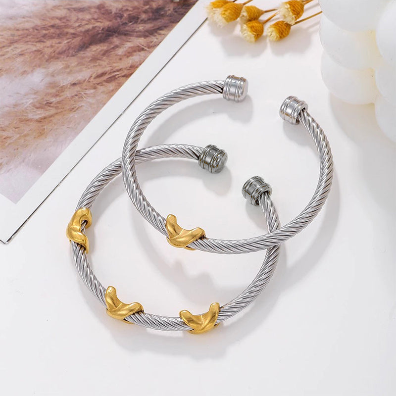 Close-up of a women's two-tone knot twisted bangle bracelet, highlighting detail.