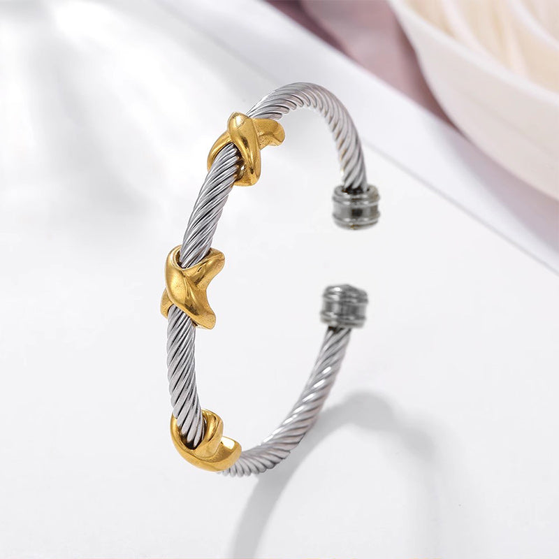 Stylish two-tone stainless steel bangle bracelet with a unique knot design for women.