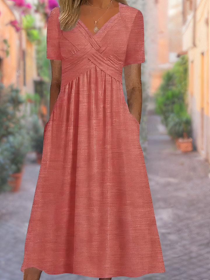 Close-up of the elegant V-neck and crisscross bodice on a women's flowing midi dress, showcasing detail.