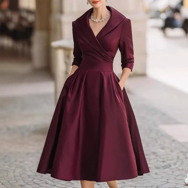 Comfortable black V-neck midi dress for women, featuring three-quarter sleeves and a flattering flared skirt for all-day elegance.