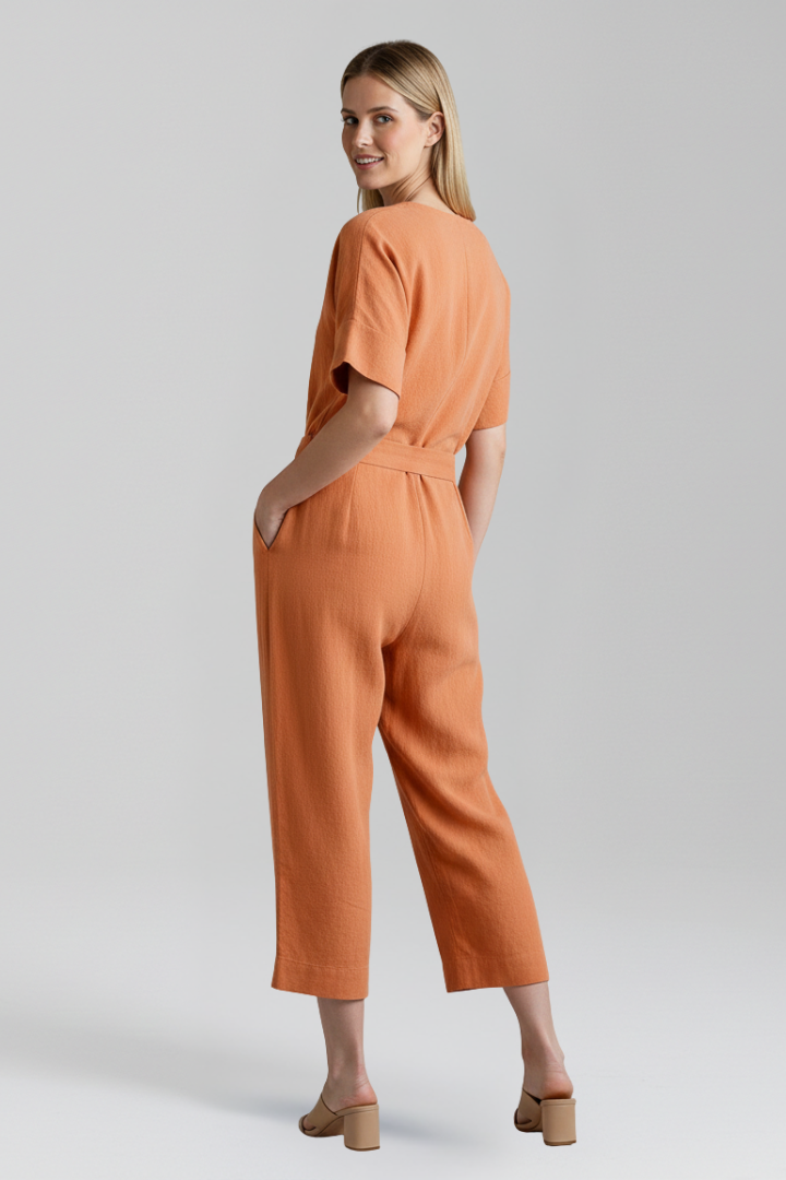 Women's V-neck jumpsuit featuring a flowing wide leg and adjustable waist tie for a flattering silhouette.