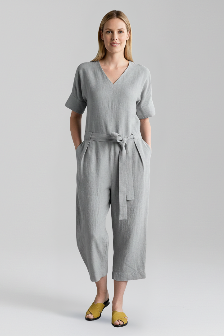 Long-sleeve V-neck women's jumpsuit with a stylish wide leg and an elegant waist tie, contemporary fashion.