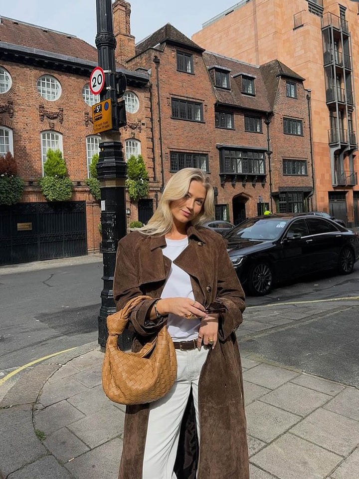 Full view of women's warm brown belted trench coat, a timeless and elegant outerwear design.