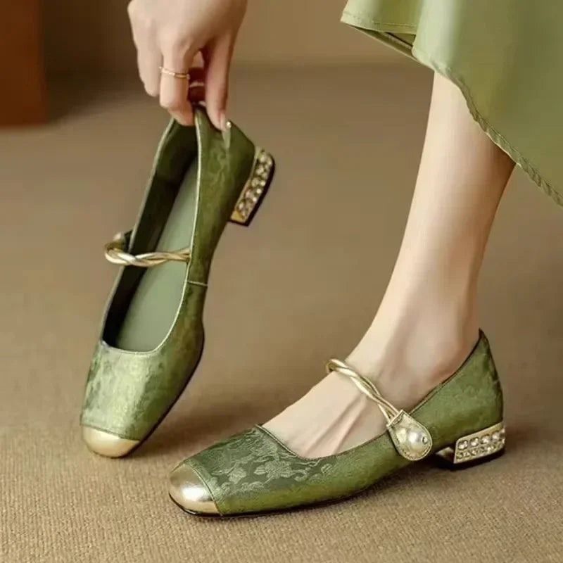 Side profile of women's elegant pearl flats, showcasing comfort design & metallic tip.