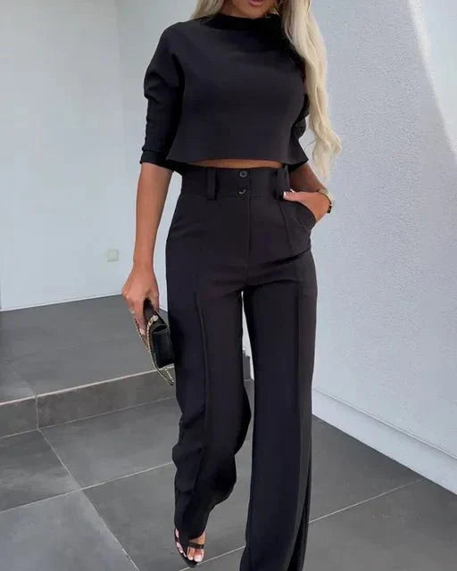 Elegant women's white two-piece set, featuring a cropped top and high-waisted tailored trousers.