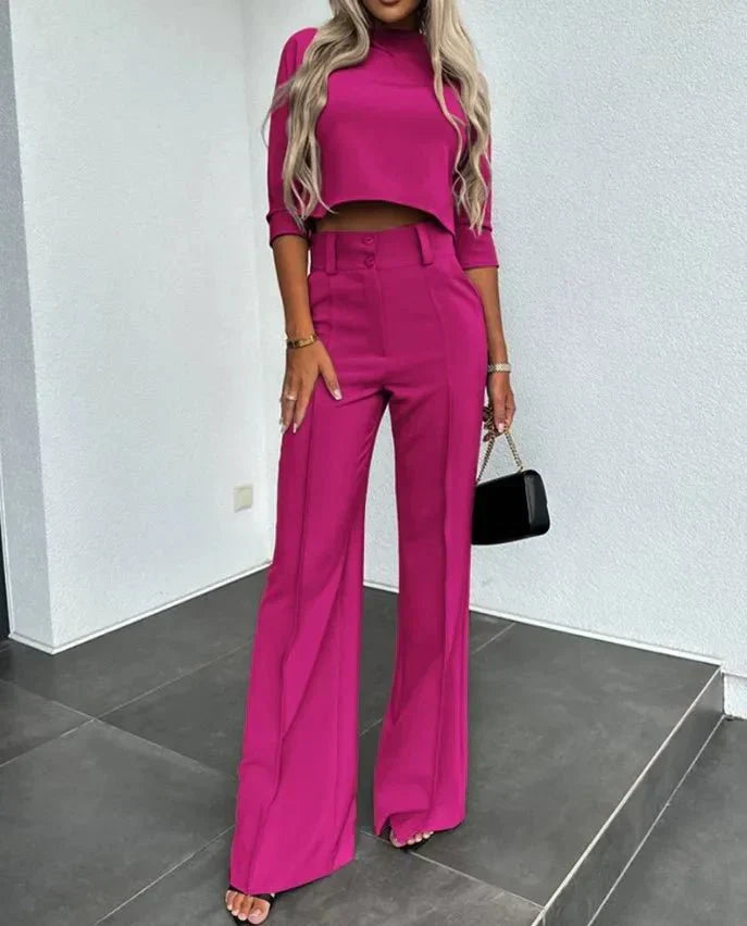 Model wearing an elegant women's two-piece set, a cropped top and high-waisted tailored trousers.