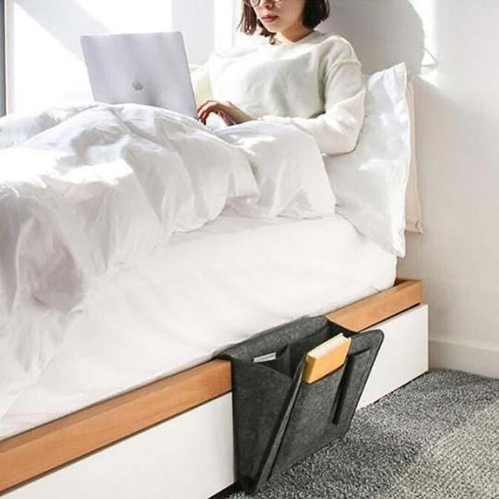 Space-saving bedside caddy made of dark grey felt, ideal for keeping essentials close at hand.