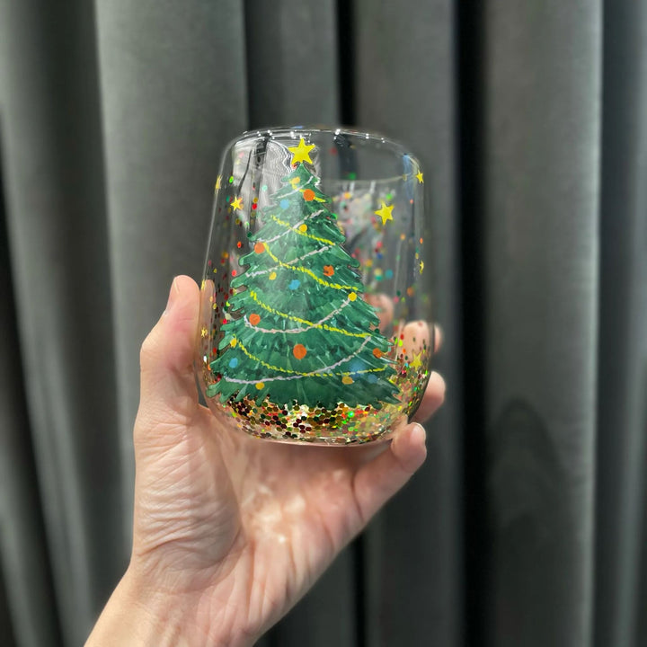 Holiday themed glass tumbler with Christmas tree design and glitter. Great for festive drinkware.