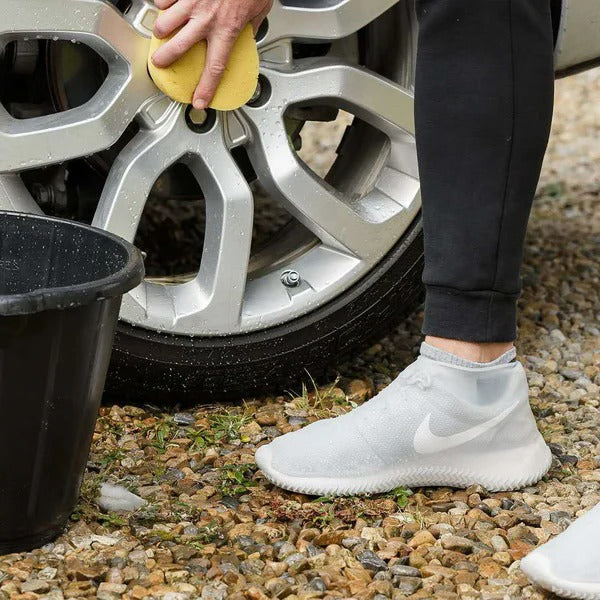 Unisex waterproof non-slip shoe covers worn over footwear, providing essential rain and mud protection for commuters.