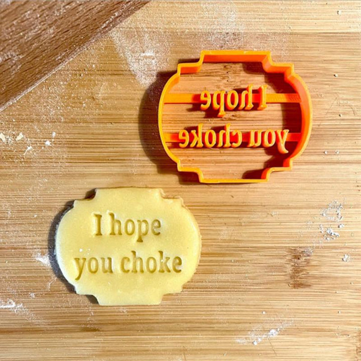 A collection of four orange plastic cookie molds, designed with fun phrases for baking enjoyment.