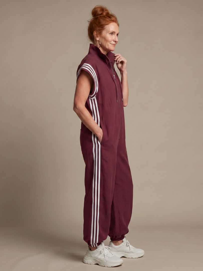 Sporty chic full-length women's jumpsuit with a relaxed fit and bold side stripe detail.
