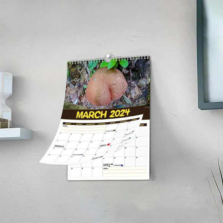 Someone writing in a Fungi Wall Calendar, demonstrating the large date squares for daily organization