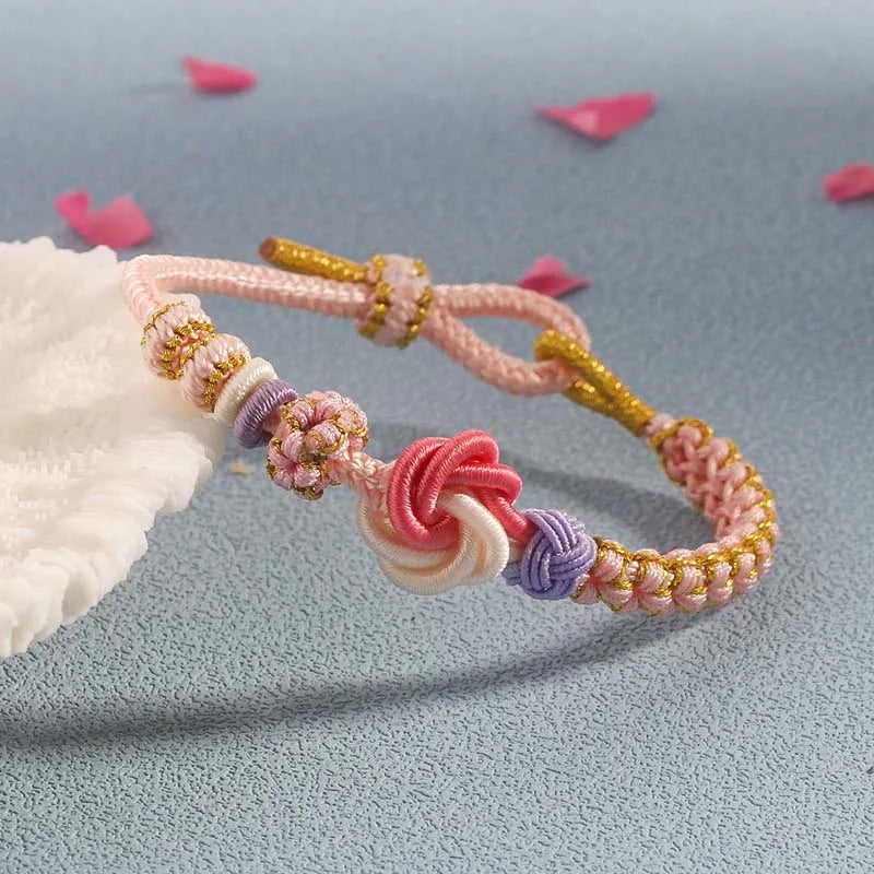 Girls' peach blossom knot braided bracelet, featuring a small metallic bead accent, stylish kids jewelry