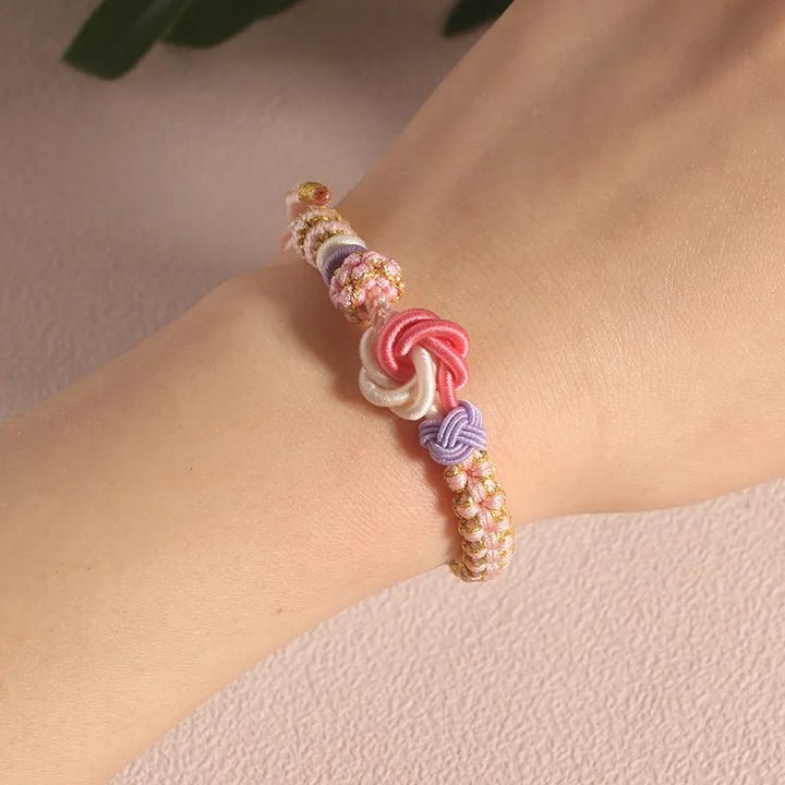 Close-up of the secure knot on a peach blossom braided bracelet, ensures it stays on for girls