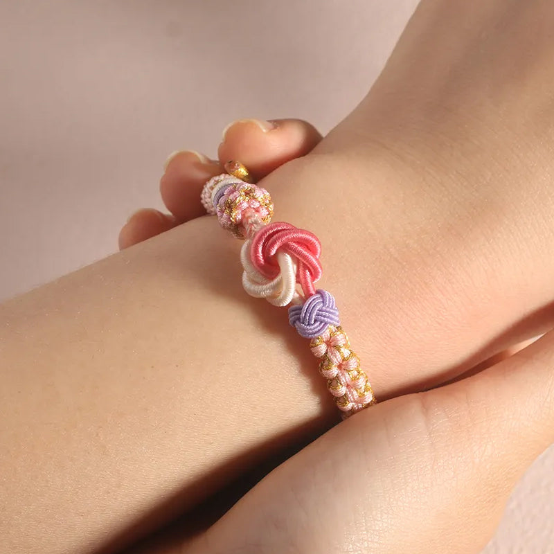Set of three girls' peach blossom knot braided bracelets in different shades, ideal for kids' jewelry gifts