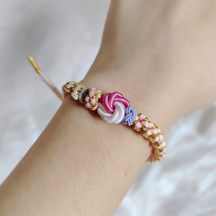 Peach blossom knot braided bracelet with charm, close up of the delicate knot work, gift for granddaughter