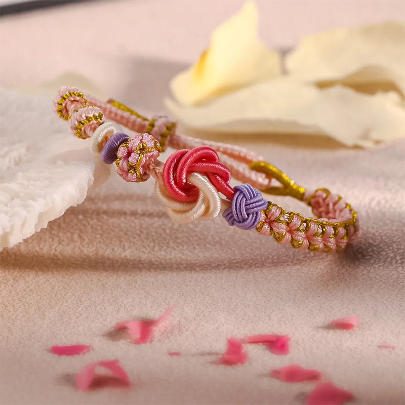 Peach blossom knot braided bracelet, unworn, displaying full length and adjustable pull-cord mechanism