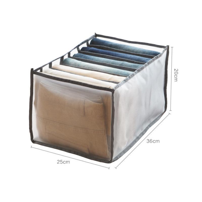 Hand placing a folded shirt into a mesh wardrobe organizer bin in a drawer