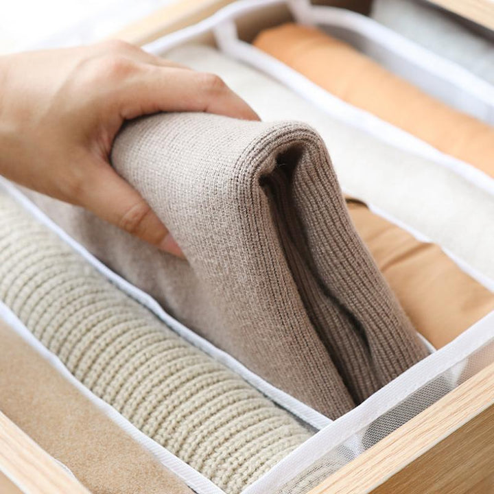Wardrobe drawer organizer in use, neatly storing folded t-shirts in a drawer