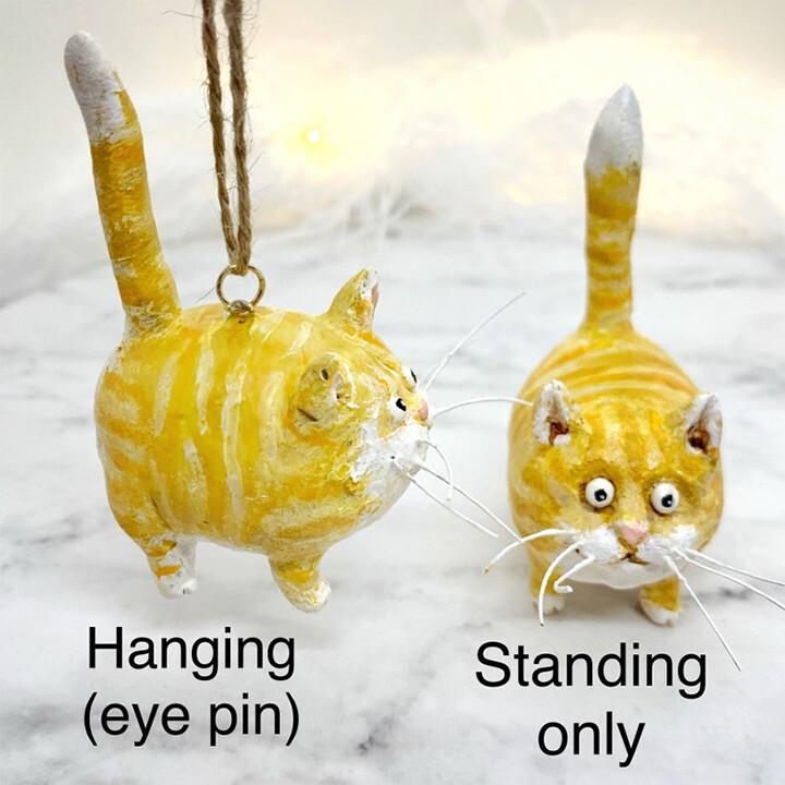 Close-up of a whimsical miniature cat figurine, showcasing delicate hand-sculpted details.