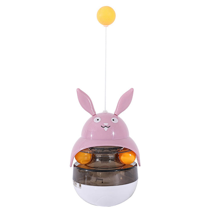 Cat playing with a red and white interactive treat puzzle feeder, promoting activity