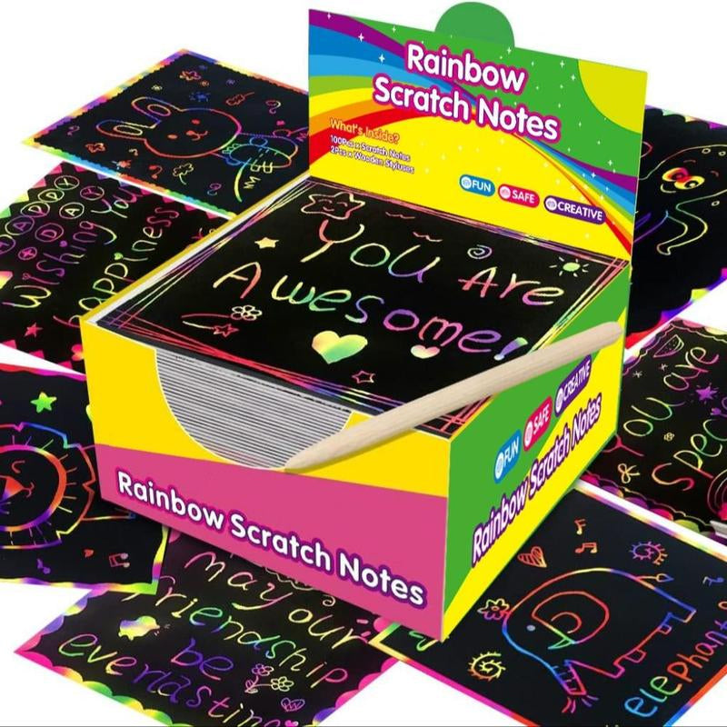 Child's hands holding a scratching tool and a rainbow scratch art sheet, focused on creative play