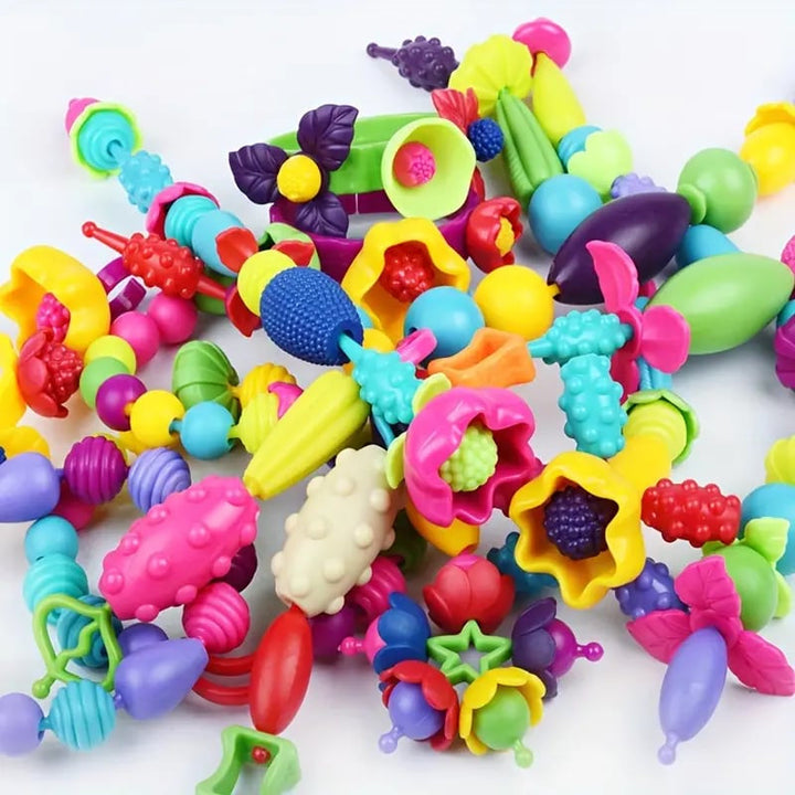Two children collaborating on jewelry from a Kids' Pop Beads DIY Kit, fostering social interaction and creative fun