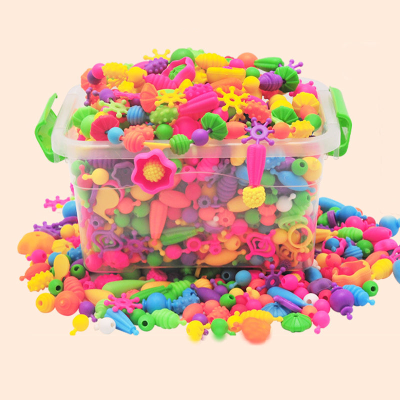 A collection of completed necklaces and bracelets made with colorful pop beads from a kids craft jewelry making kit