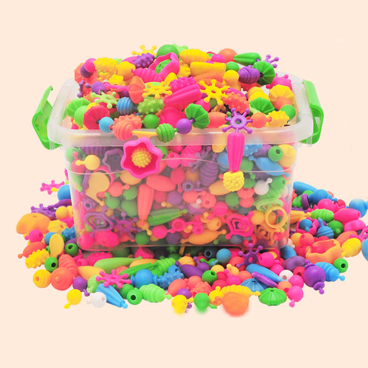 A collection of completed necklaces and bracelets made with colorful pop beads from a kids craft jewelry making kit