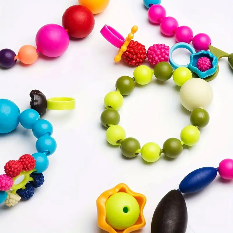 Assortment of uniquely shaped snap pop beads in bright colors, ready for assembly in a kids' craft project