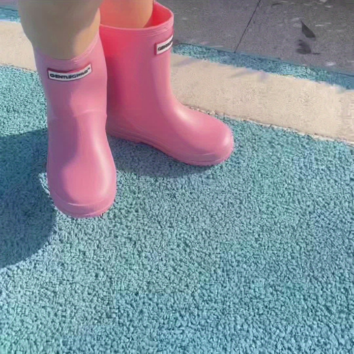 Kids playing in waterproof rain boots; durable, non-slip wellies for muddy outdoor fun.