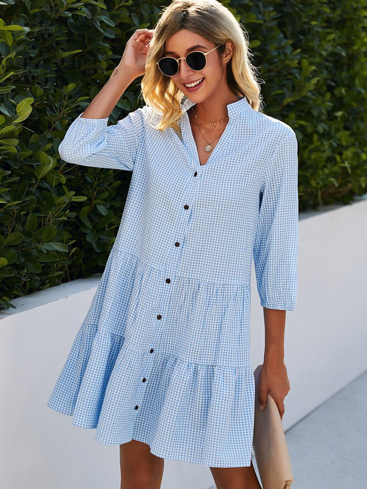 Light blue gingham tiered mini dress with button-down front & stand collar. Perfect playful summer style for women.