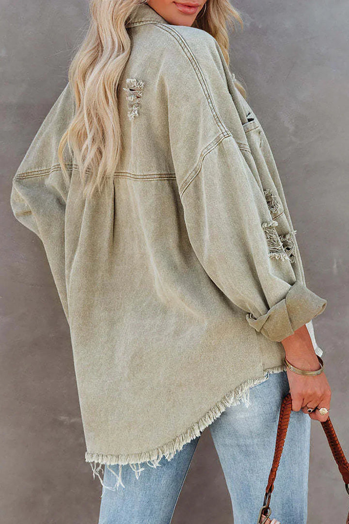 Trendy light green distressed denim jacket for women with character. Oversized button-up spring style.