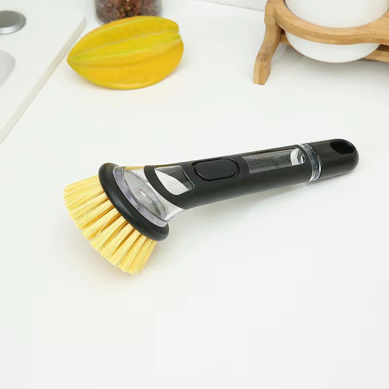 Product shot of the kitchen cleaning brush, emphasizing its long handle and soap dispensing feature.