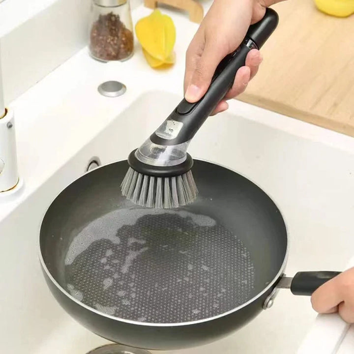 Close-up of the soap dispenser button on a long-handle kitchen dish cleaning brush, easy to use.
