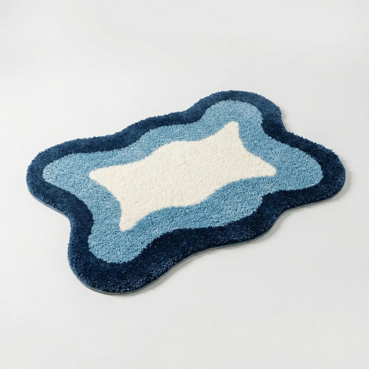 Close-up of a soft, unisex luxury bath rug. Features a distinctive Flowique wave pattern & non-slip backing for comfort.