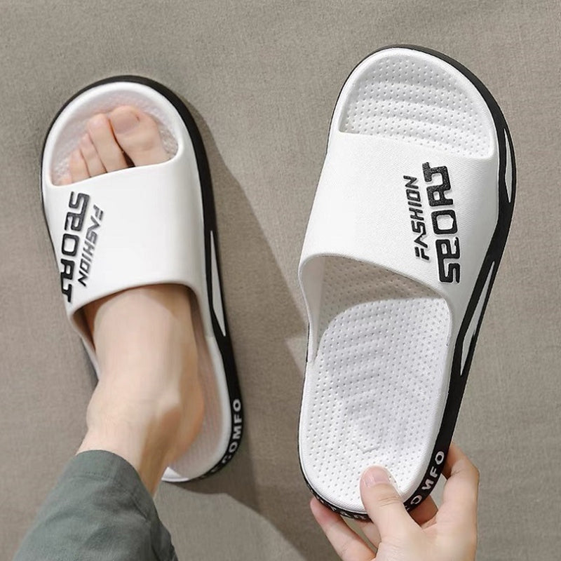 Pair of men's red sport slide sandals on a sandy beach, comfort and summer style