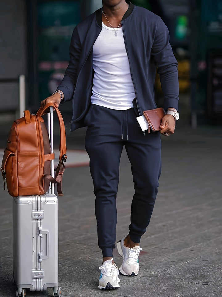 Dark grey men's tracksuit set with a full-zip jacket and comfortable jogger pants for travel or casual wear.