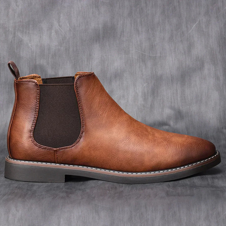 Side view of men's classic brown Chelsea boots, showing elastic side panels & sleek design for autumn.