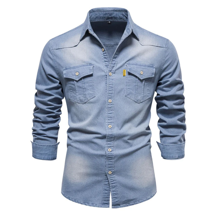 Close-up of fabric on a men's blue denim long sleeve button-up shirt, texture visible