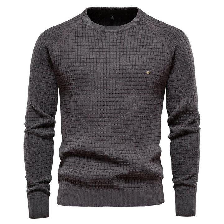 Close-up of a men's classic knit long sleeve pullover, highlighting the rich texture