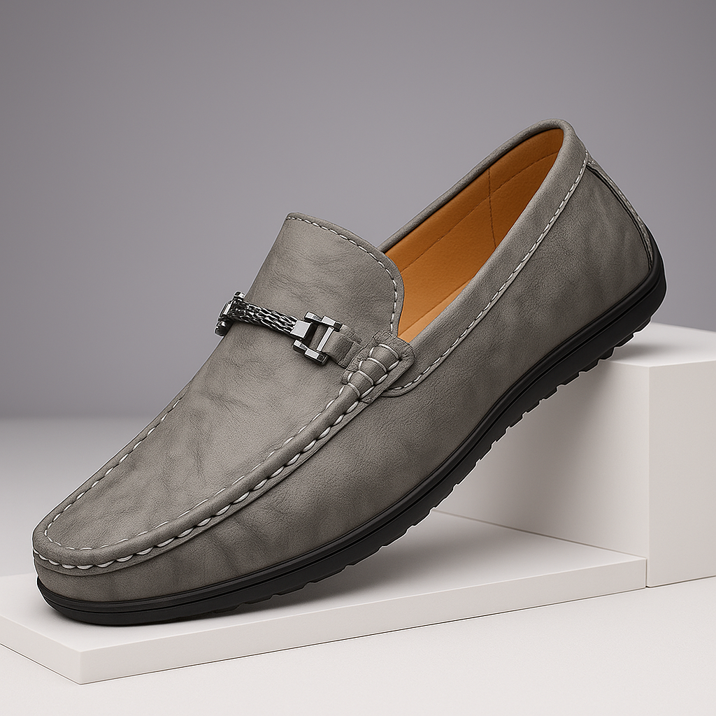 Pair of men's elegant black leather bit loafers on a hardwood floor