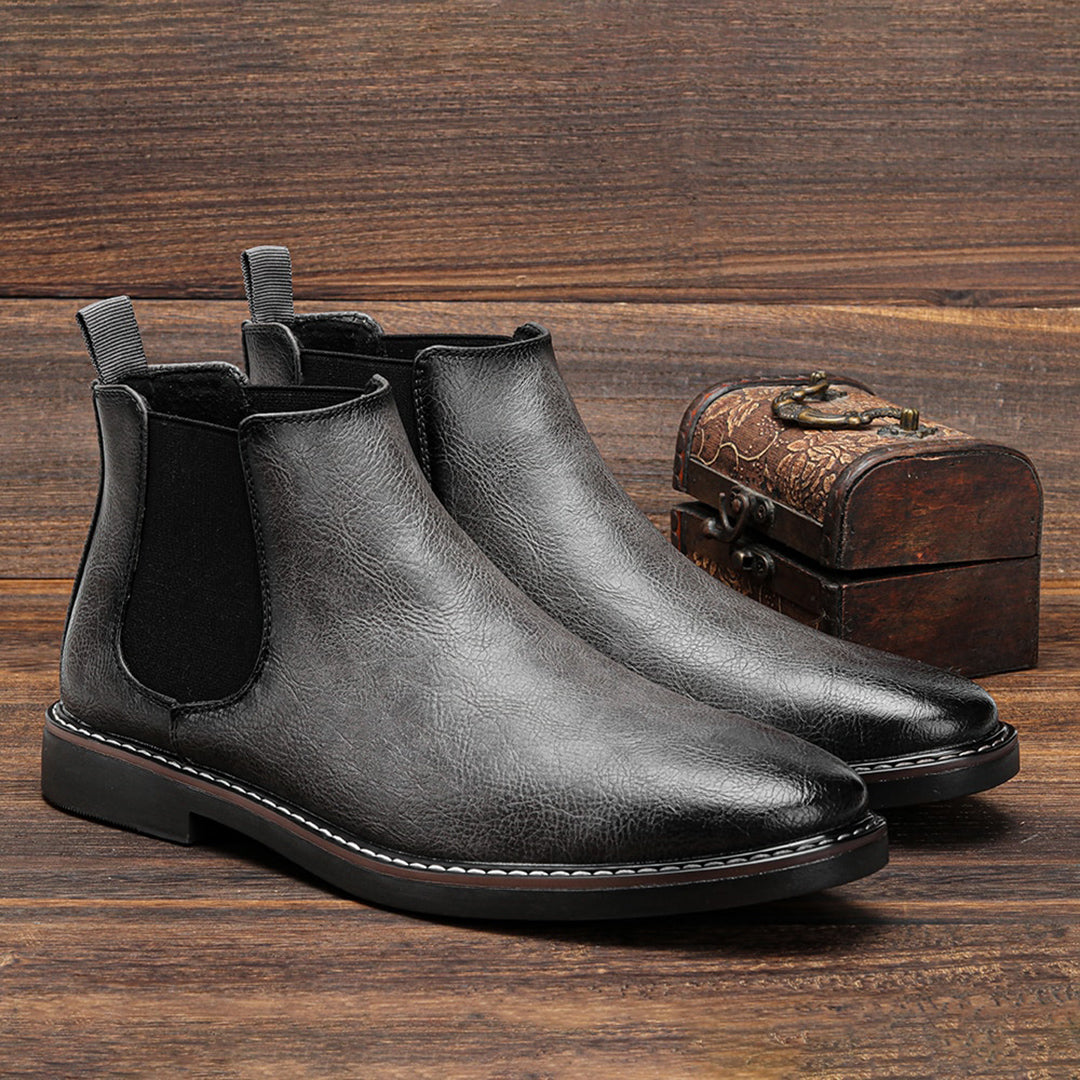 Stylish men's black leather Chelsea boots with elastic side panels, perfect for any outfit