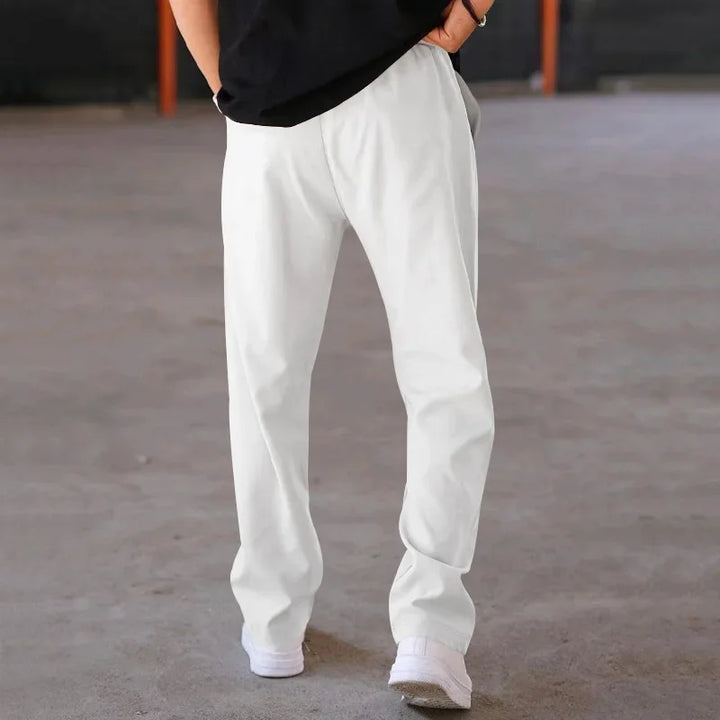Stack of folded men's loose-fit formal trousers in assorted colors, ready for retail display.