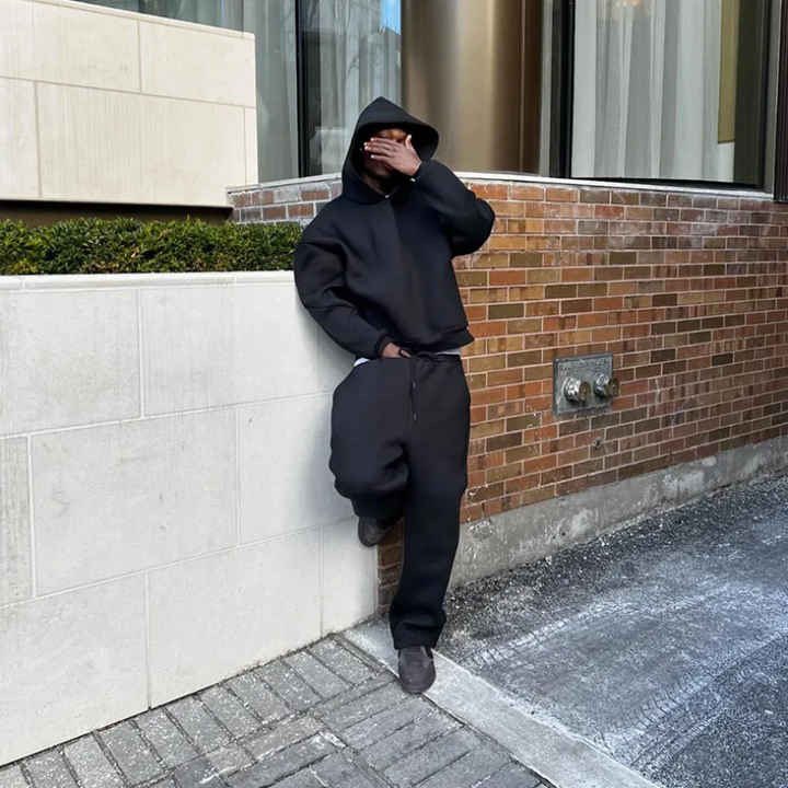 Two-piece men's apparel: a minimalist hooded sweater paired with cuffed jogger pants